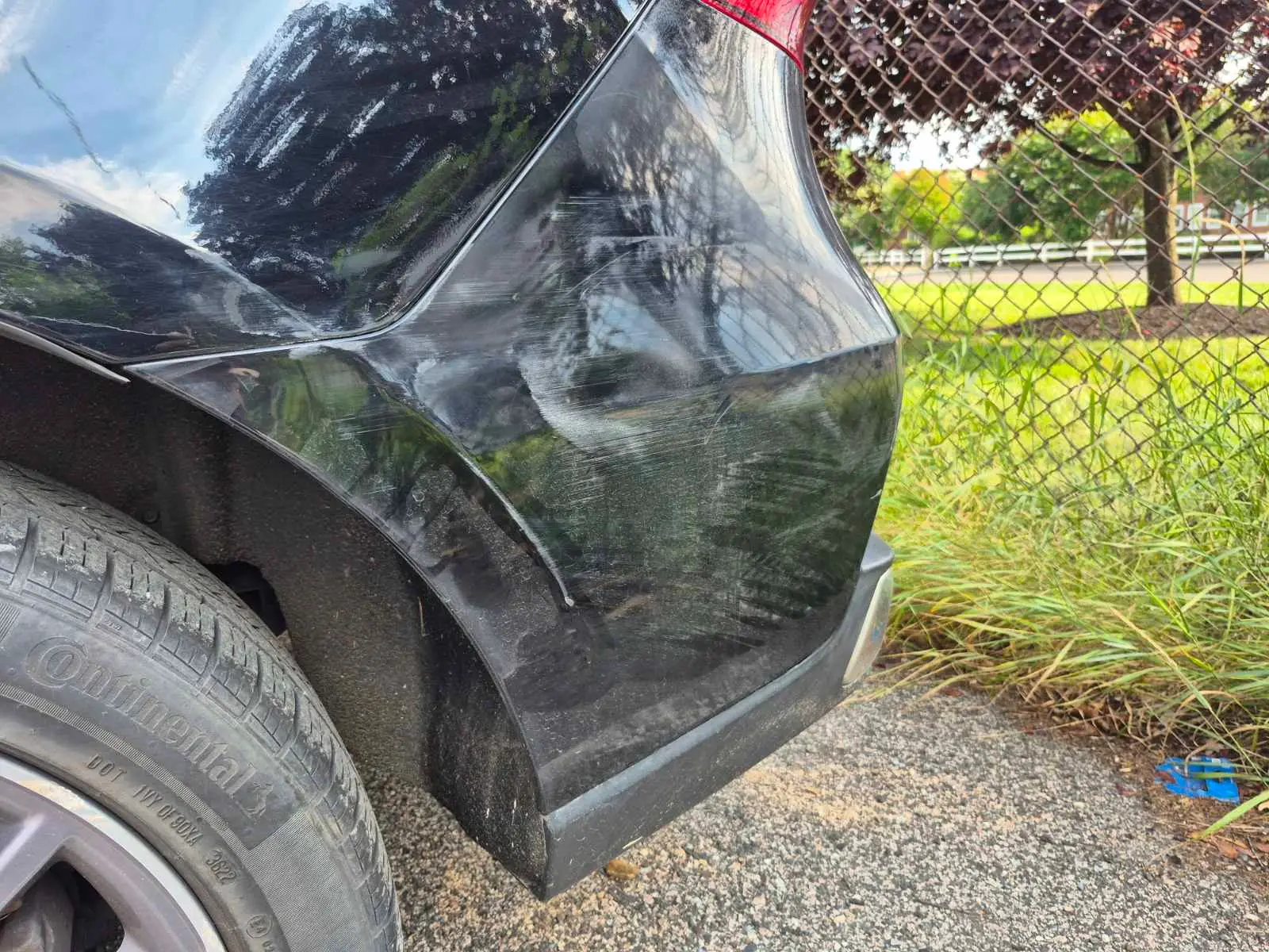 Scratched black rear bumper before correction